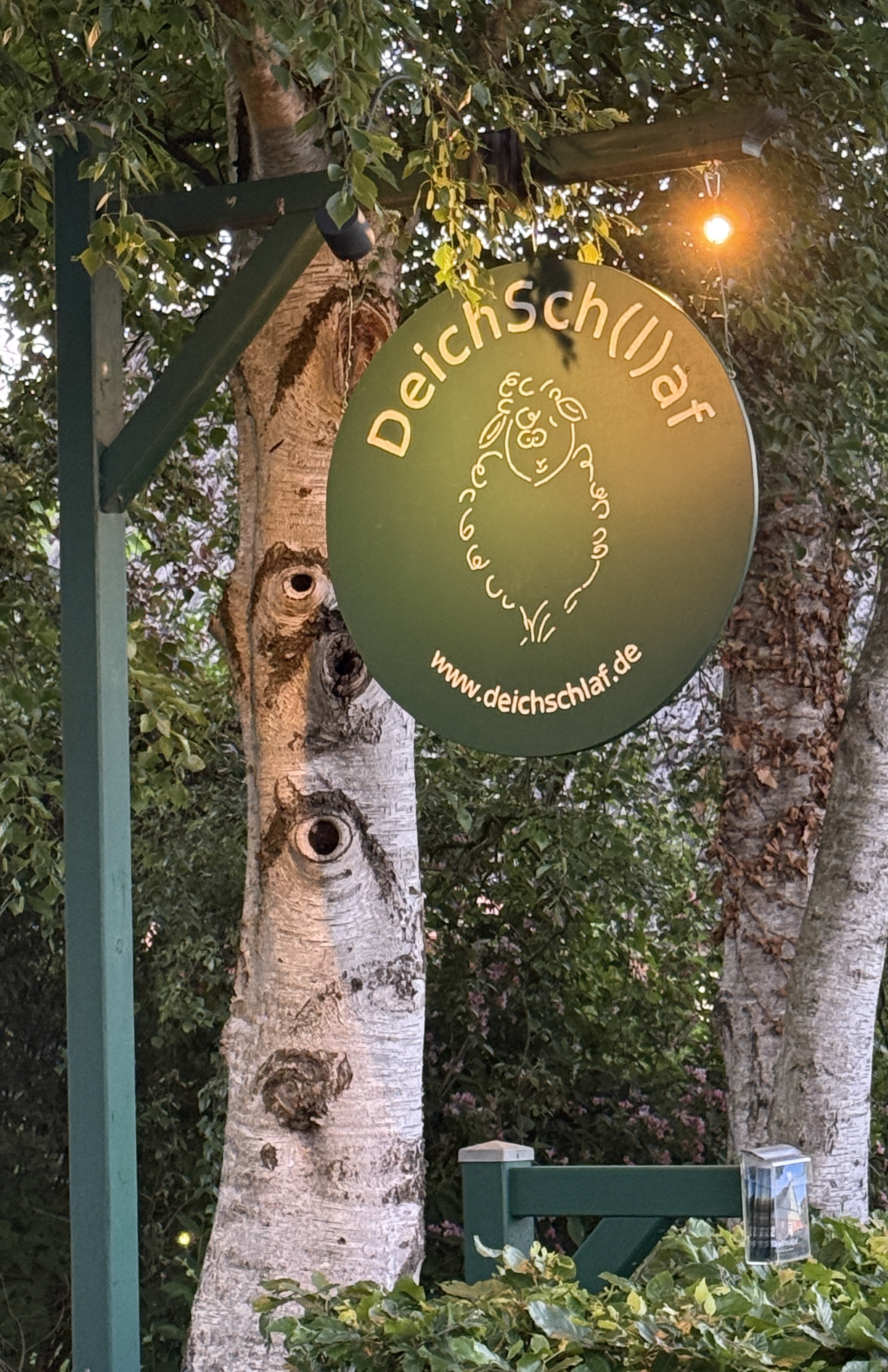 Das handgefertigte DeichSch(l)af-Schild in der Abenddämmerung